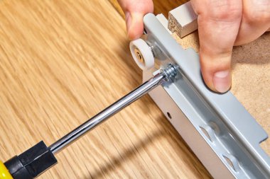 Assemble furniture, screwed screw-bolt with using screwdriver. clipart