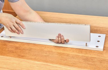 Mobilya assembler ahşap iğne kullanarak çekmece bölümlerini bağlar.