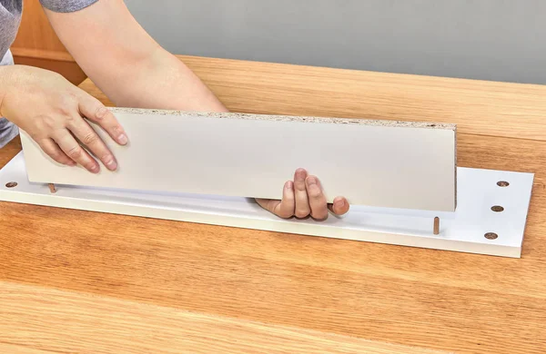 Mobilya assembler ahşap iğne kullanarak çekmece bölümlerini bağlar.