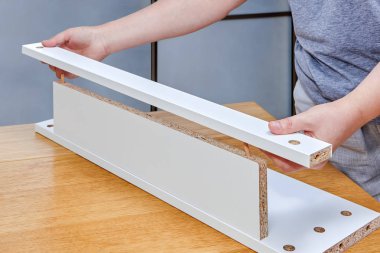 Kadının el mobilya parçaları düz bir araya getirmek paketi ile ahşap dowelled eklem, yakın çekim.