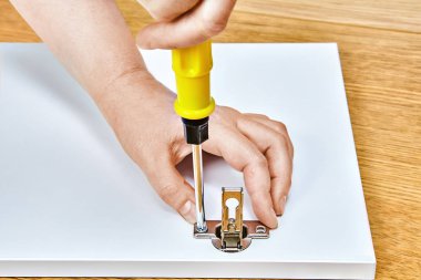 Vida mobilya kapı menteşeleri bir tornavida ile ahşap masa mobilya assembler tarafından mobilya montajı hazır sıkılır.