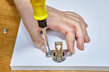 Mobilya assembler mobilya kapı menteşeleri sunta, mobilya montajı hazır yapılmış ahşap masa yüzeyi içinde vida sıkılaştırır.