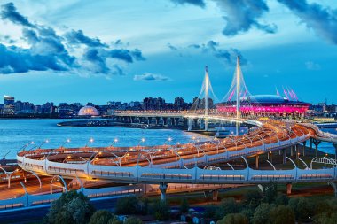 St. Petersburg, Russia - August 22, 2018: cable-stayed bridge over the river Neva in the twilight, the stadium Zenith Arena is located nearby. clipart