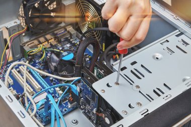 Tamirci kişisel bilgisayarın sabit disk bir vida untightening yakın çekim.