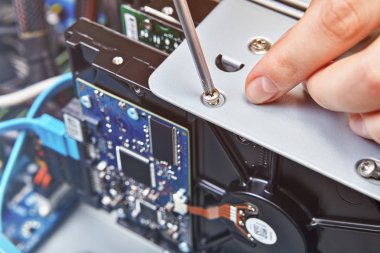 Tamirci unassembled bilgisayar sistem biriminin Hdd vidası untightening, yakın çekim.