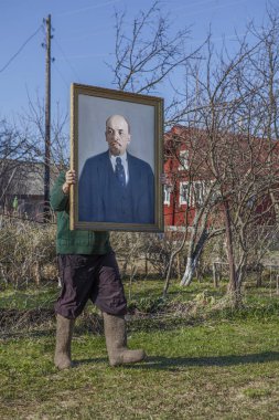 Karelya, Rusya - 1 Mayıs 2016: bir portre Vladimir Lenin önünde tutan Çimenlerin arasında uzun adımlarla keçe çizmeler ayakkabılı bilinmeyen bir adam.