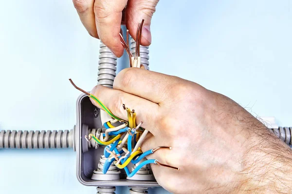 Trabajador aprieta los cables de la caja de conexiones eléctricas . — Foto de Stock
