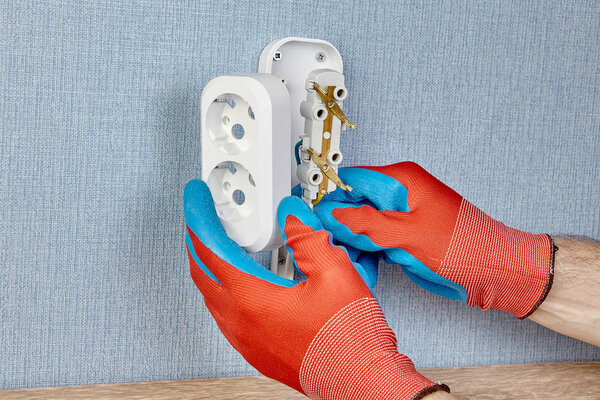 Электрик устанавливает розетку
.