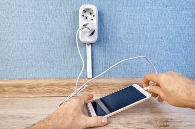 Kullanıcı cep telefonunu şarja takıyor.