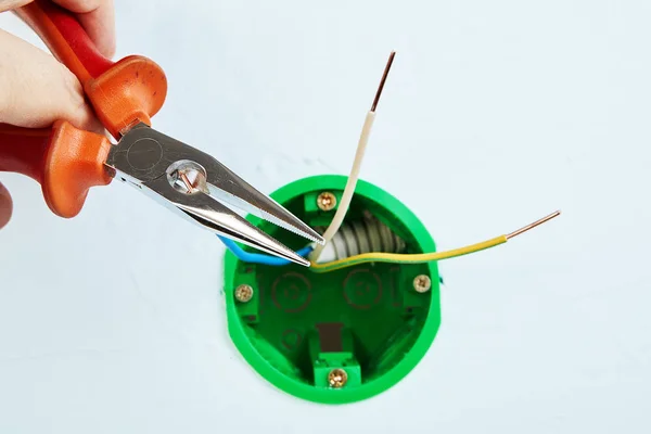 Instalación de caja eléctrica redonda con herramienta de mano . — Foto de Stock