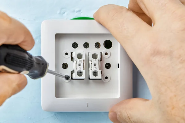 Tightening screw in light switch. — Stock Photo, Image