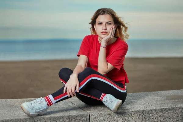 Adolescente chica se sienta en la playa . —  Fotos de Stock