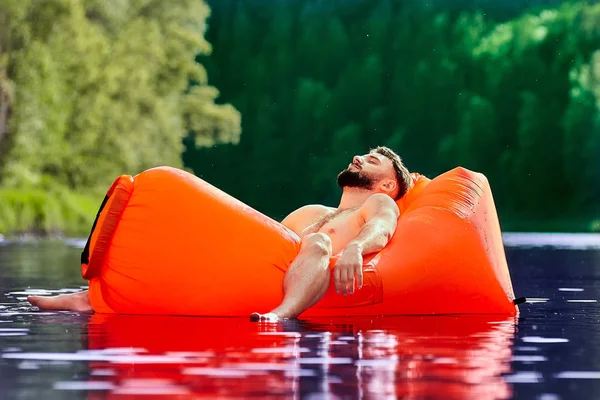 Tourist schläft auf Luftcouch im Wasser. — Stockfoto