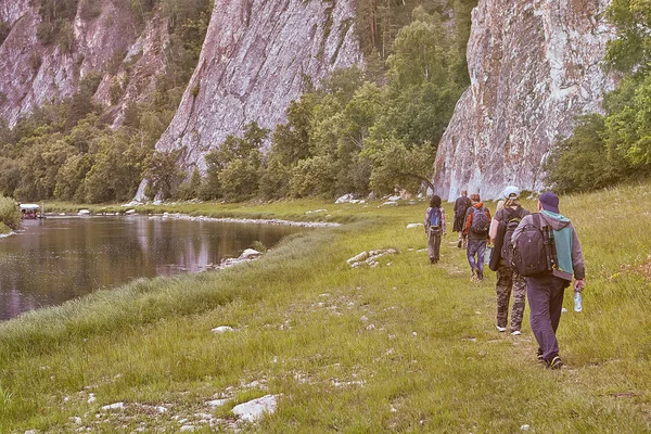 A group of hikers walking along the river. — Stock Photo, Image