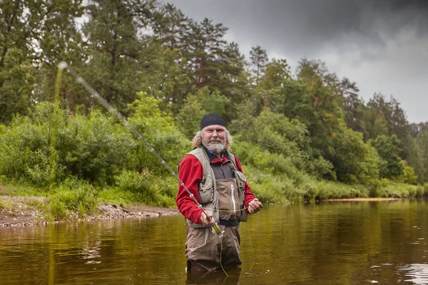 Uomo maturo durante la pesca a mosca nel fiume . — Foto Stock