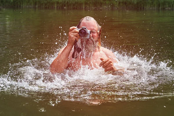 Bílý muž dělá obrázky ve vodě. — Stock fotografie