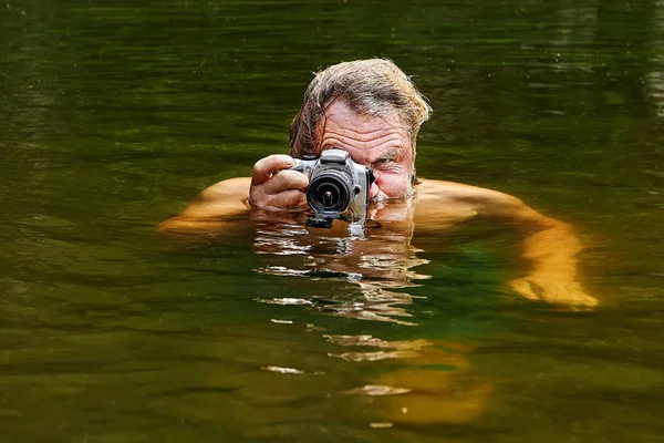 Foto's maken door volwassen man in water. — Stockfoto