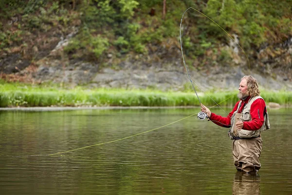 Pesca con mosca en ropa impermeable en el río . — Foto de Stock
