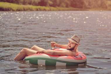 Nehirde şişme halka üzerinde yüzme.