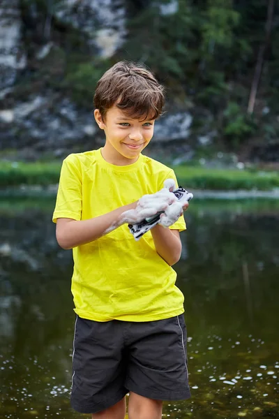 Boy destroys device with water. — Stock Photo, Image
