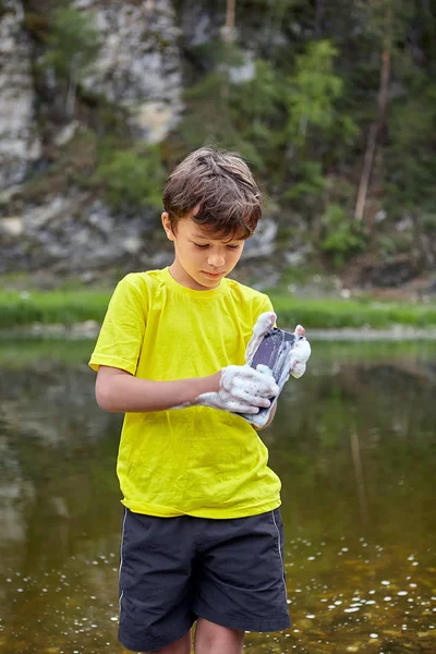 Boy destroys phone with water. — Stock Photo, Image