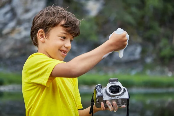 Boy cleans CMOS image sensor in digital camera. — Stock Photo, Image