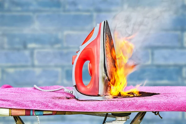 Clothes iron and ironing board in the fire.