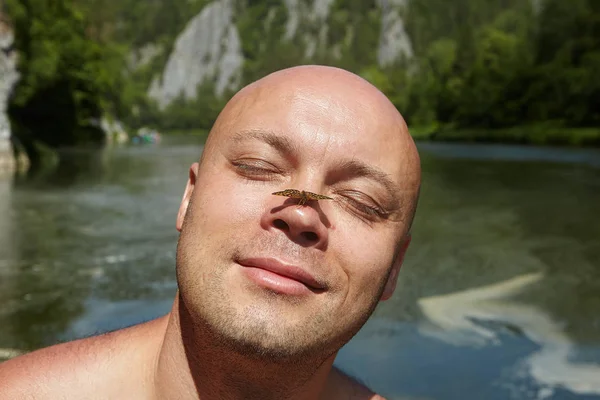 Schmetterling auf der Nase eines glatzköpfigen Mannes. — Stockfoto