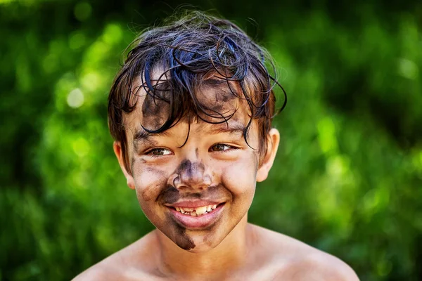 Um rapaz sorridente sujou a cara. . — Fotografia de Stock