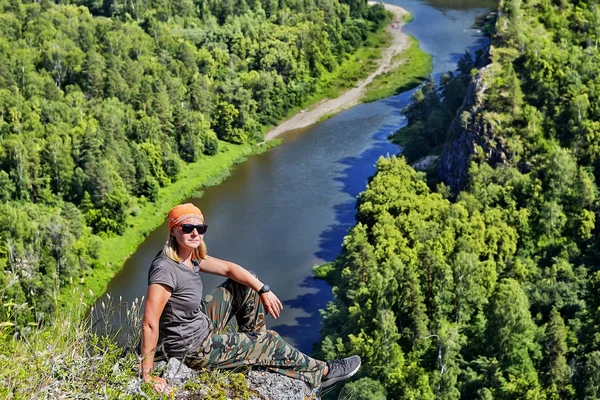 Kobieta Hiker siedzi na szczycie góry. — Zdjęcie stockowe