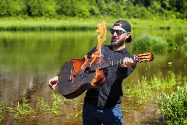 Gitarist yanan bir gitar çalmaktan çekinir..