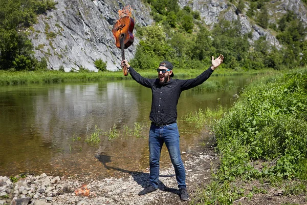 Ein verrückter Musiker zündete seine Gitarre an. — Stockfoto