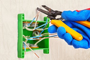 Tamirci, elektrikli bakır kabloların uçlarını kesiyor..