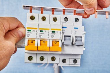 Installation of automatic fuses on a DIN rail. clipart