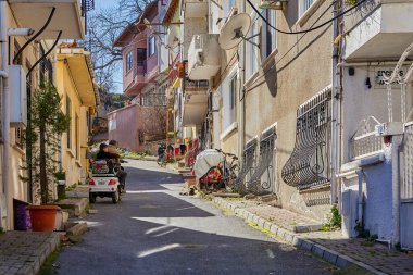 İstanbul, Türkiye - 13 Şubat 2020: Adalar ilçesi, düşük katlı konut binaları ve Princes Adaları 'nın bir turistik merkezi olan dar caddelerindeki elektrikli araçlar.