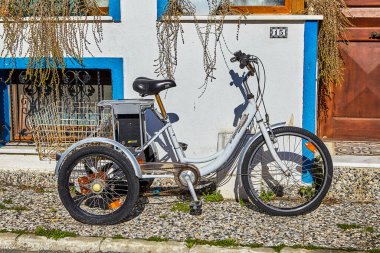İstanbul, Türkiye - 13 Şubat 2020: Elektrikli motoru olan üç tekerlekli bisiklet ön kapının yanında park halinde. Adalar Bölgesi 'ndeki Prensler Adalarından biri olan Büyükkada adasının çevre dostu taşımacılığı.