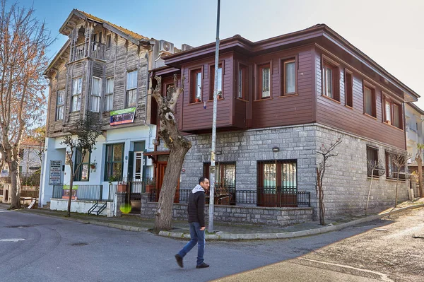 土耳其伊斯坦布尔 2020年2月13日 阿达拉地区王子岛之一的布于卡达岛 一个过路人走过两座两层房子 其中一座是旧木屋 第二座是新石屋 — 图库照片