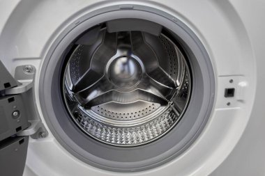 Otomatik çamaşır makinesinin açık kapısı boş bir çelik iç davulu gösteriyor. Bu davullarda çalışan elmas tasarımı.