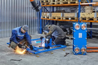 St. Petersburg, Rusya - 24 Aralık 2018: Metal fabrikası, kaynak makinesi ve öğütücü ürün imalatı üzerinde çalışıyor.