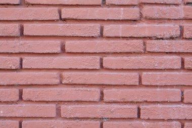 Boyalı duvarın kırmızı-kahverengi tuğla dokusu. Düşük kontrastlı pembe arkaplan.