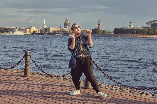 Genç adam Saint-Petersburg 'un arka planında dans ediyor. Kafkasyalı mutlu erkek turist.