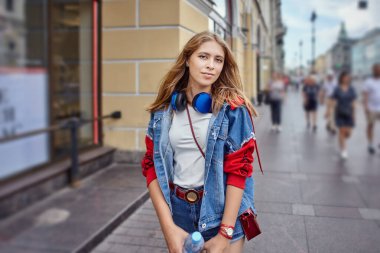 Sarışın kadın kalabalık caddede yürüyor. Şehir merkezinde şortlu, 20 yaşında beyaz, çekici bir kız..