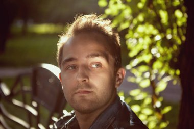 Gündüz vakti halka açık parkta yürürken 27 yaşında genç, dalgın, beyaz bir adamın portresi..