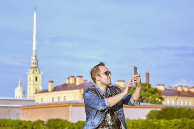 Erkek turist, Saint-Petersburg, Rusya 'nın arka planında selfie çekiyor..