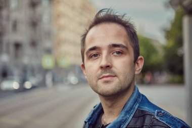 Gündüz vakti şehir sokaklarında yürürken 27 yaşında beyaz bir adamın portresi..