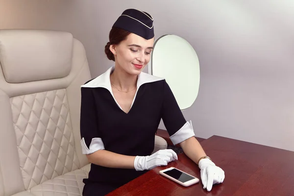 Eine Kabinencrew sitzt auf einem Sitz für First-Class-Passagiere im Business-Jet. — Stockfoto