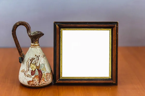 Vintage beyaz boş afiş ile antik Vase.Isolated kalıp ahşap masa üzerine alay