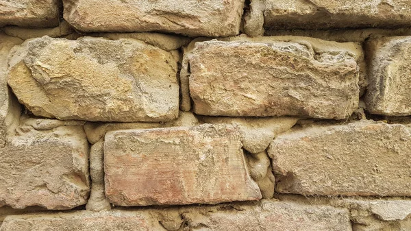 Taş tuğla duvar duvar kağıdı arka plan dokusu. Eski sarı taş tuğla yakın çekim