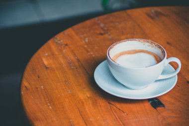 coffeeshop dışında wodden masada sıcak latte