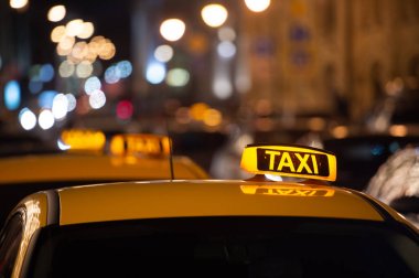 Gece bir taksinin çatısında taksi tabelası var.